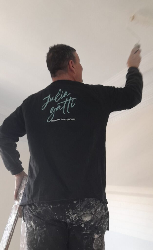 Trabajador de Julia Gatti pintando una casa